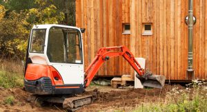 Mini Digger excavating the ground by the side of the house